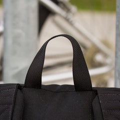 Close-up of GORUCK black rucksack handle with outdoor urban background