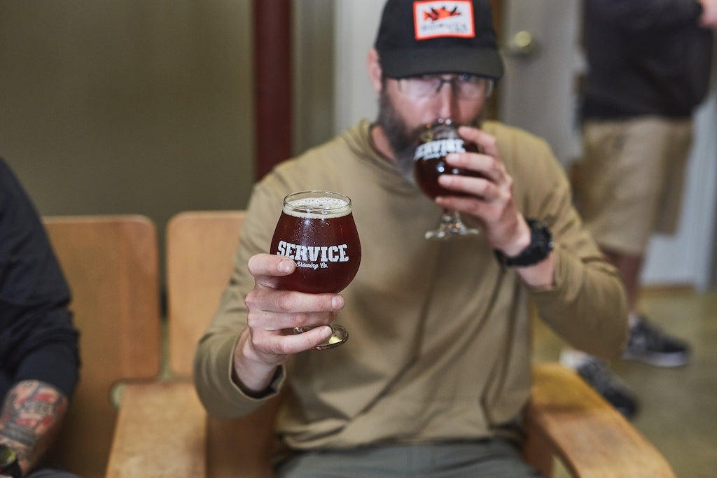 Man in a cap holding and drinking a 