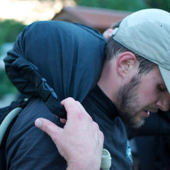 Man wearing GORUCK rucksack outdoors with padded shoulder strap and hydration tube
