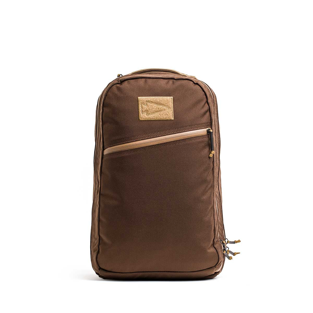 The Double Bullet Ruck w/ Bombproof Laptop Compartment - 18L is a brown travel backpack with double compartments, a diagonal front zipper pocket, tan upper patch, and an ultra-protective laptop sleeve.
