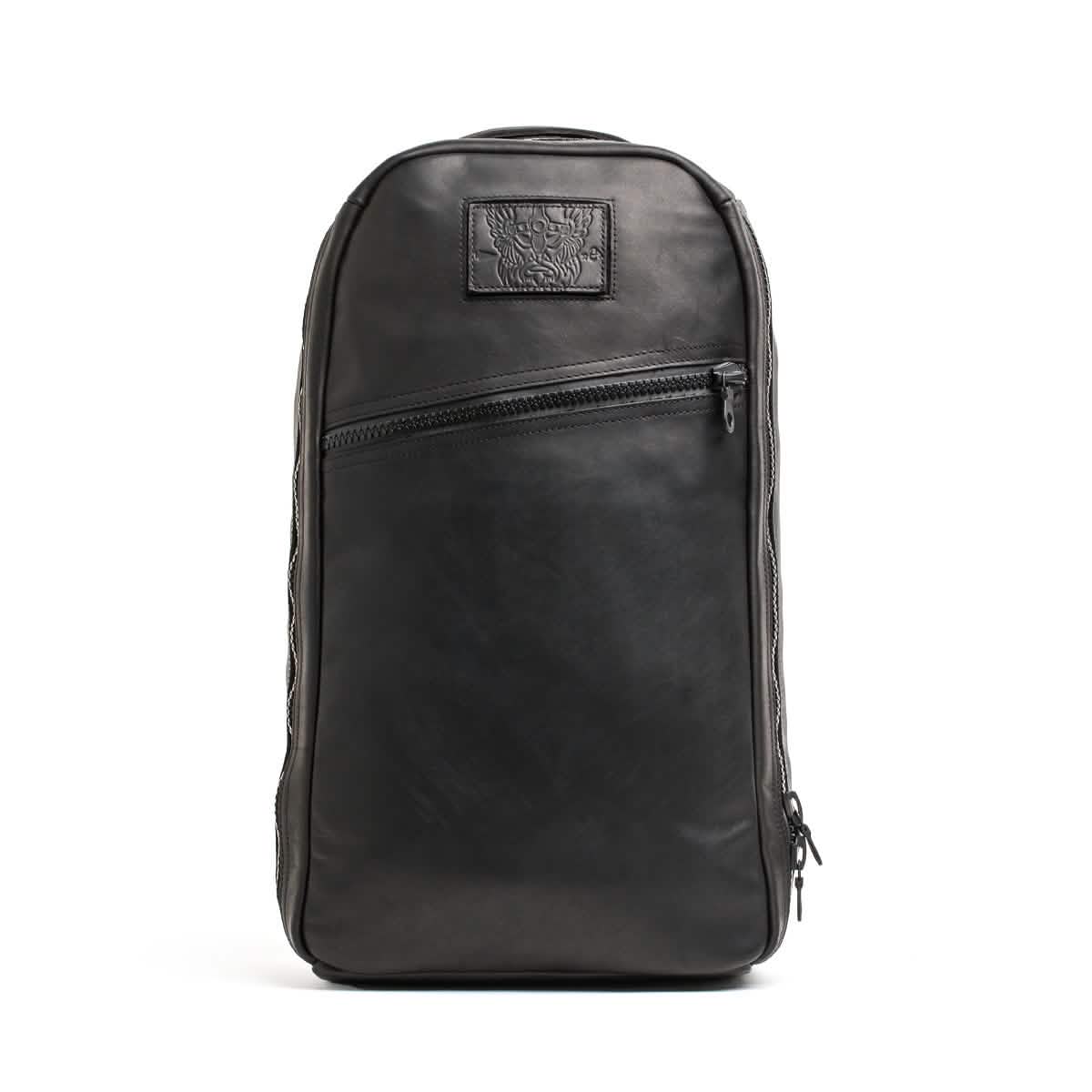 Introducing the Bullet Ruck x Carryology - Berserker Viking by GORUCK: a sleek black leather backpack with a rectangular shape that draws inspiration from the Viking Bullet Ruck. It boasts a front zipper pocket and a subtle embossed design on a small patch near the top, all while maintaining a modern, minimalist look.