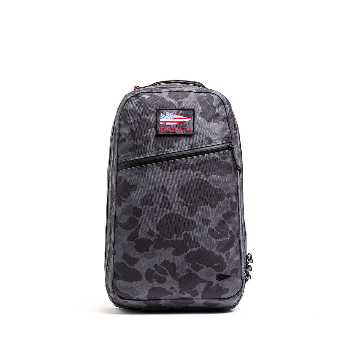 The Double Compartment Bullet Ruck - Ballistic Nylon Cordura - 18L is a gray camo travel backpack with a front zipper pocket, bombproof laptop compartment, and a small USA flag patch near the top.