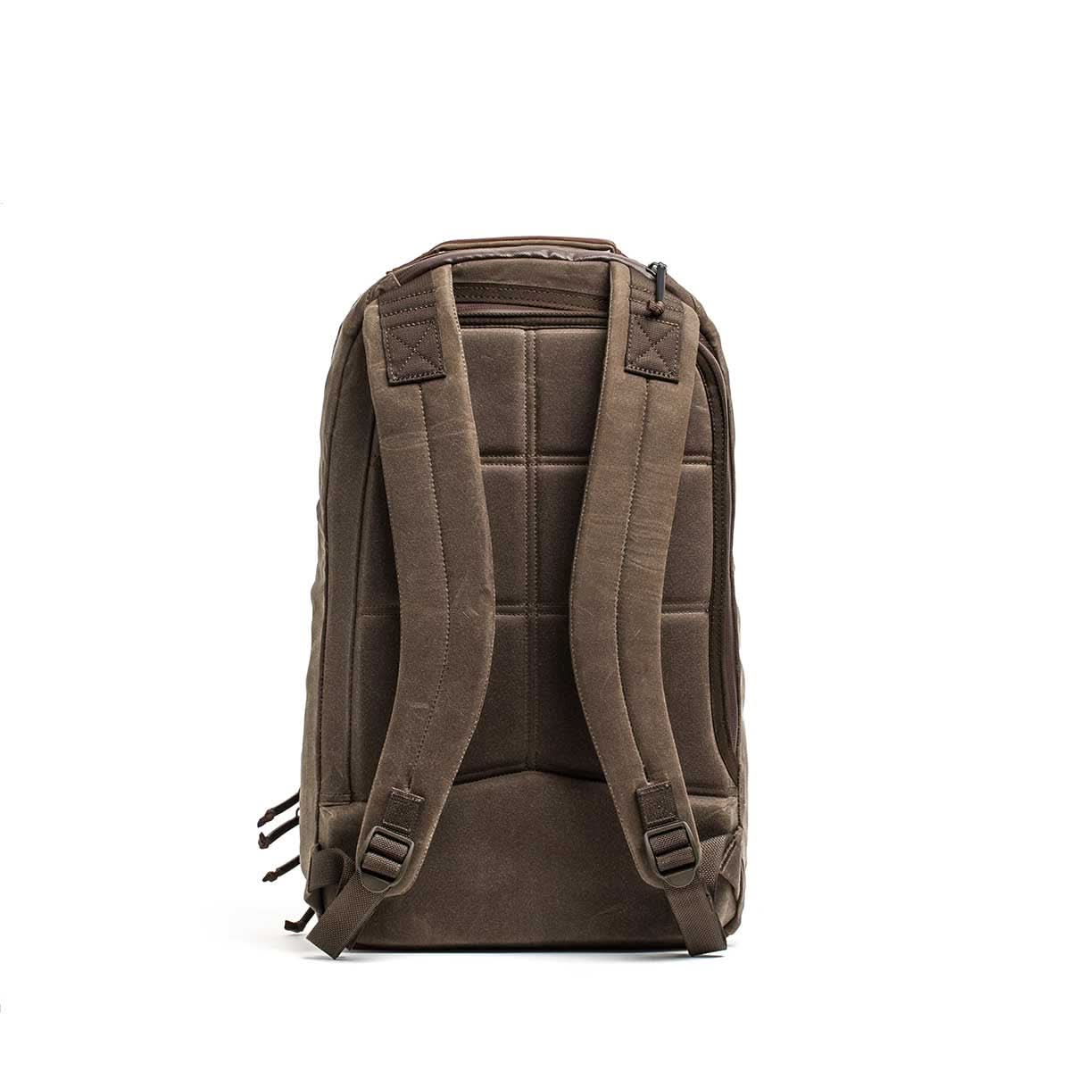 Waxed Canvas 18L Bullet Ruck backpack shown from the back on a white background, featuring padded straps, a quilted back panel, and durable waxed canvas construction.
