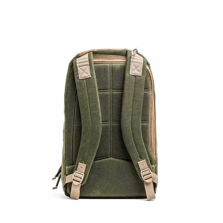 The Waxed Canvas 18L Bullet Ruck, shown from the back, features padded straps and a top handle. This durable backpack has dual compartments and includes the Scars Lifetime Guarantee for peace of mind.