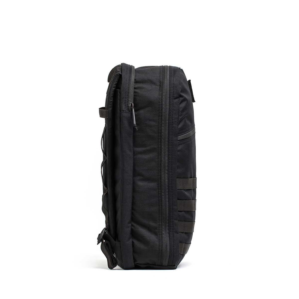 Side view of the Bullet Ruck USA Throwback, a black tactical daypack with multiple zippers, MOLLE webbing, and attachment loops—all made from durable CORDURA—shown against a white background.