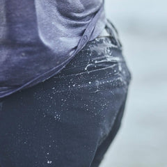 Close-up of a person wearing wet Navy GORUCK Challenge shorts with water droplets on fabric