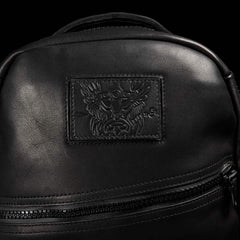 Close-up of black GORUCK rucksack with embossed logo patch and visible zipper details