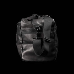 GORUCK black leather kit bag with adjustable shoulder strap on black background