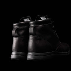 Pair of black GORUCK rucking boots against a black background, showcasing sturdy leather design and padded collar