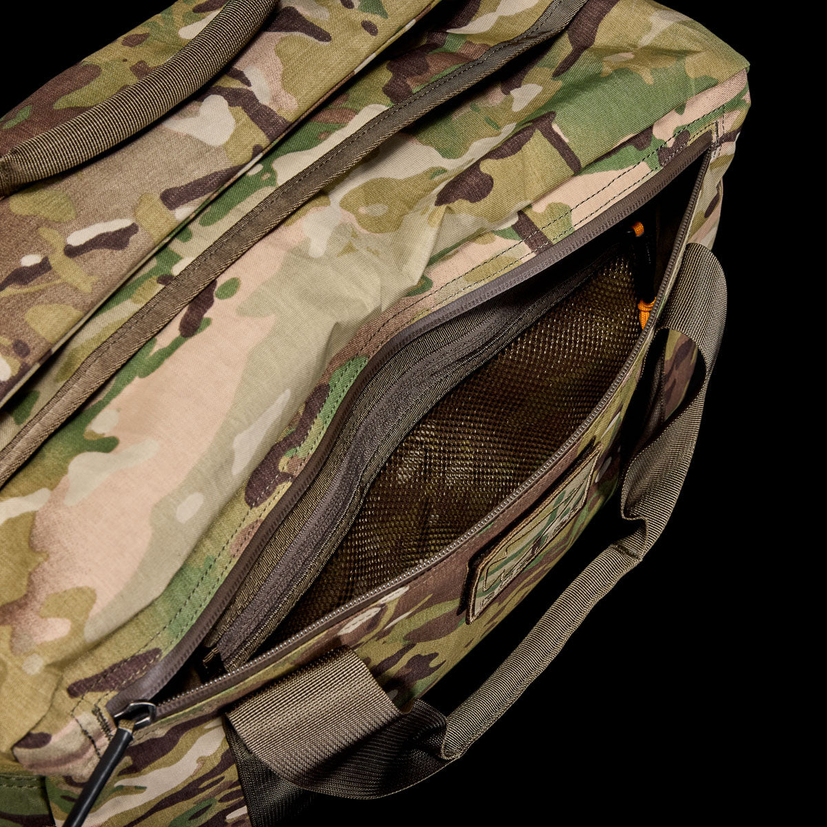 The Kit Bag - X-PAC in camouflage features a partially open zippered pocket showing a mesh compartment inside, crafted from durable X-PAC VX21 fabric inspired by Special Forces gear.