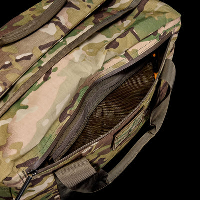 The Kit Bag - X-PAC in camouflage features a partially open zippered pocket showing a mesh compartment inside, crafted from durable X-PAC VX21 fabric inspired by Special Forces gear.
