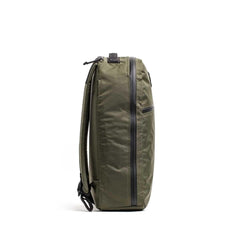 Side view of GORUCK Bullet 15L backpack in dark green with waterproof zippers and stash pocket