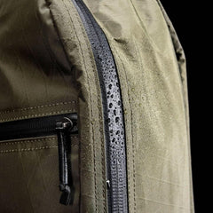 Close-up of green GORUCK Bullet Ruck 15L backpack with water droplets on waterproof zipper