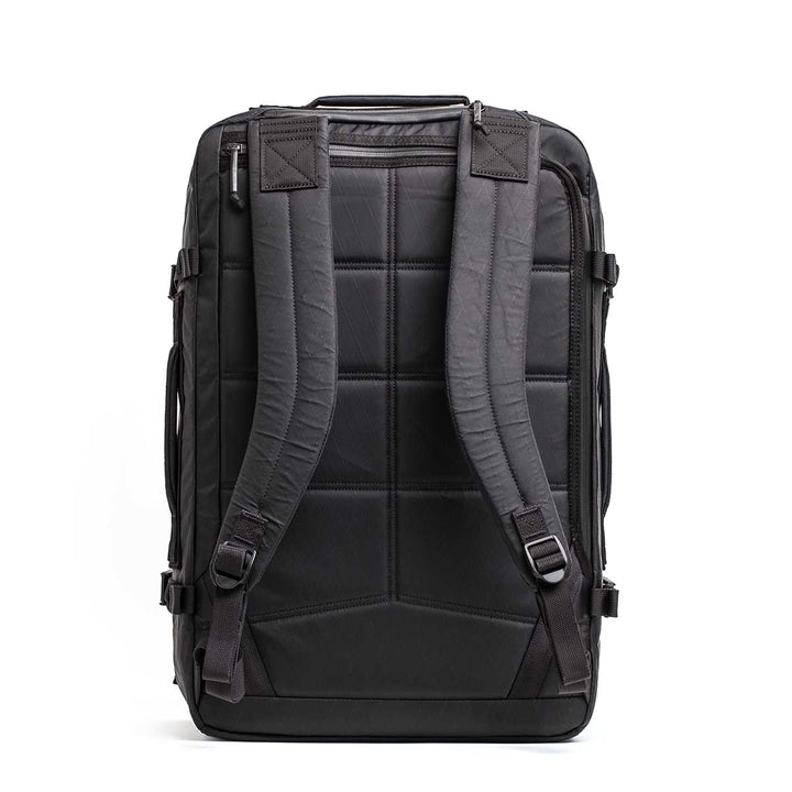 The GR3 - X-PAC is a black rectangular carry-on backpack, shown from the back with padded straps and quilted details. Made from waterproof material, it's built to last and comes with the Scars Lifetime Guarantee.