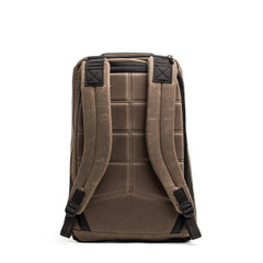 The GR1 USA - Heritage by GORUCK is displayed upright against a white background. This brown rucksack boasts padded straps and back support, featuring black accents and visible stitching on the waxed duck canvas for a sturdy and ergonomic look.