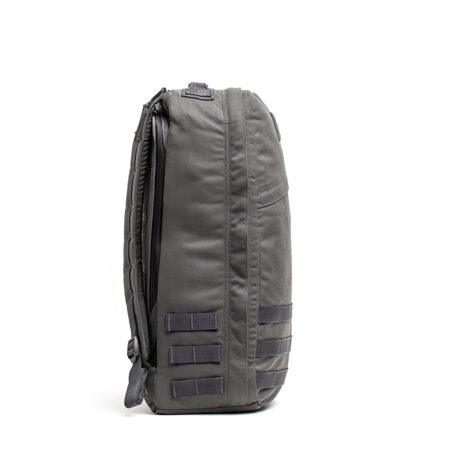 Side view of the gray GR1 USA - Cordura rucksack, built to Special Forces grade standards, with multiple loops and padded shoulder straps on a white background.