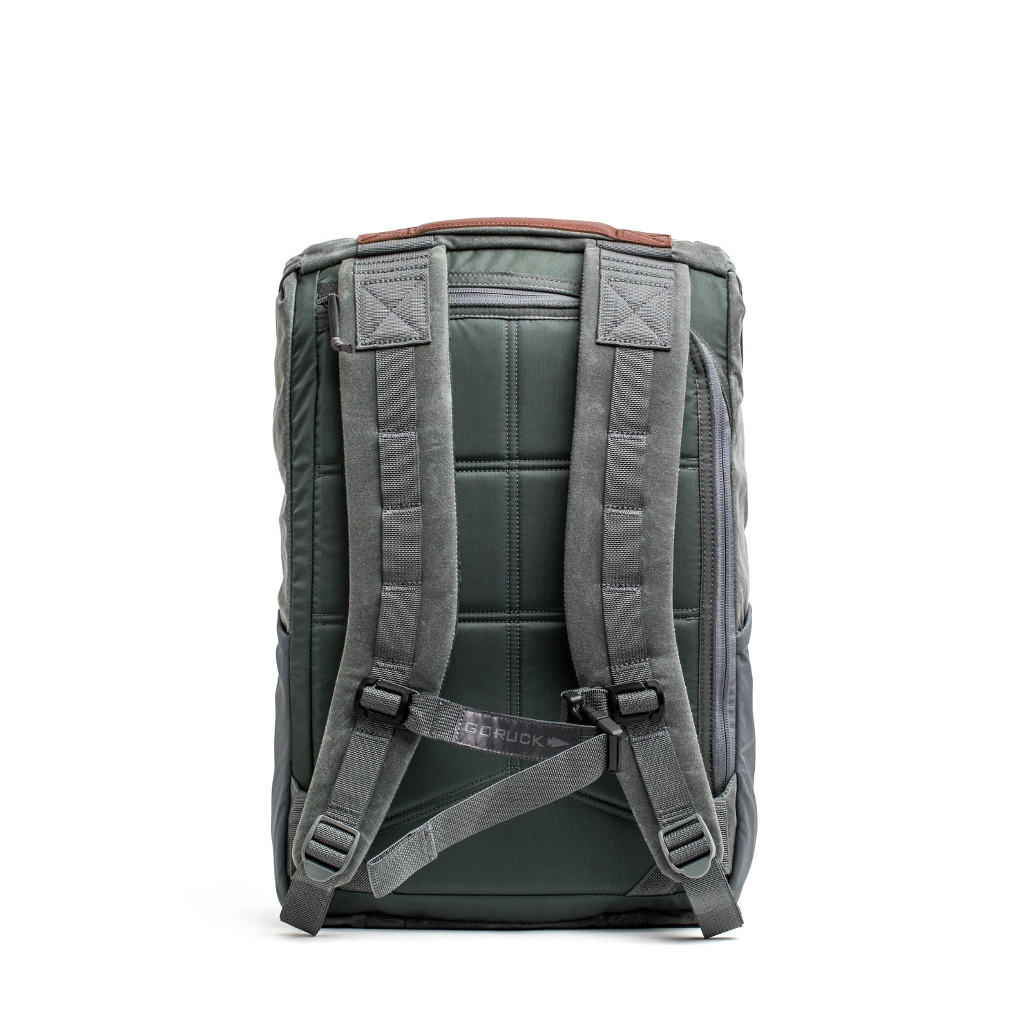 A green M24 rucksack from GORUCK with gray padded straps, displayed from the back. This modern rucksack highlights a rectangular shape, visible stitching, and a small brown accent at the top. Crafted from durable waxed canvas, the brand name is imprinted on the back strap.