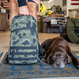 A person holds the Bullet Ruck Classic - Ballistic Nylon Cordura 15L daypack while a brown dog lies on the floor beside it in a cozy room.