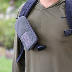 close-up of a durable GORUCK strap pouch attached to a backpack strap on olive green tactical gear