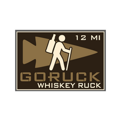 A hiker with a bottle on backpack, text "GORUCK Whiskey History Ruck" on brown arrowhead badge, celebrating rucking events like the whiskey ruck Knoxville.