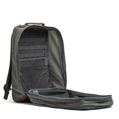 The GR2 - Heritage Waxed Canvas backpack in gray is open, displaying an organized interior with multiple pockets and compartments.