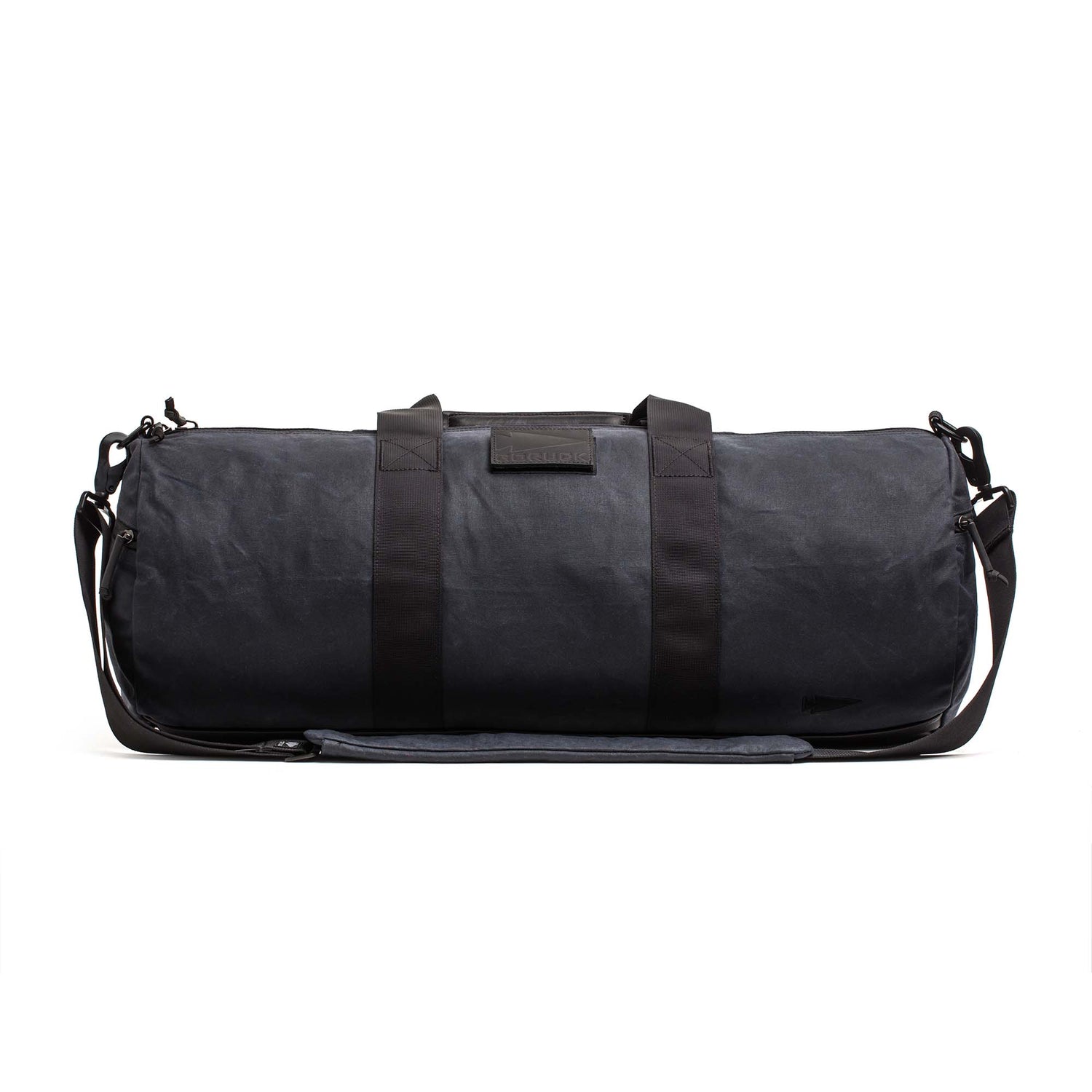 The Gym Bag - Waxed Canvas features classic black waxed canvas, two handles, a shoulder strap, and a minimalist design, all set against a white background.