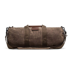 The Gym Bag - Waxed Canvas is a brown 38L gym bag with handles, a shoulder strap, and leather accents, displayed on a white background.