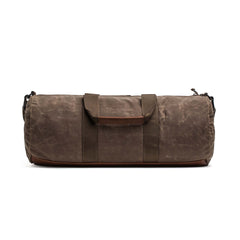 The Gym Bag - Waxed Canvas is shown in brown with handles and a shoulder strap, viewed from the front on a white background.