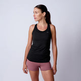 Woman wearing GORUCK black athletic tank top and mauve shorts, studio background