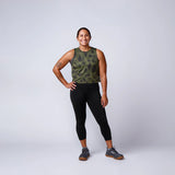 Woman in athletic camo tank top and black leggings, modeling GORUCK rucking gear studio shot