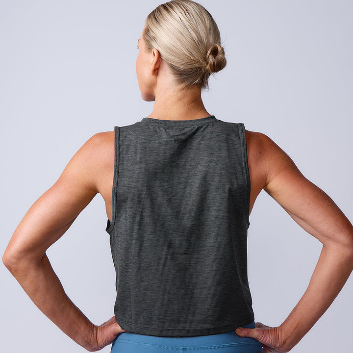 A blonde woman with her hair in a bun is seen from the back wearing a sleeveless dark gray Women’s USA Performance Tank - ToughMesh, made in Italy.