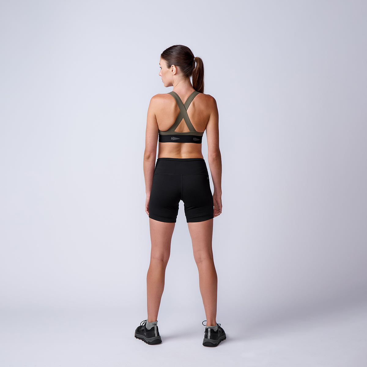 Woman wears ToughFlex Women’s Biker Shorts and sneakers, standing with her back to the camera against a plain light gray background.