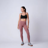 Woman in athletic wear modeling GORUCK rucking leggings and sports bra studio shot