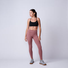 Woman wearing Women’s Training Leggings Pocket - ToughFlex and a black sports bra stands against a plain light background, looking to the side.