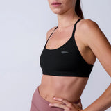 Woman wearing GORUCK black sports bra and mauve leggings, fitness apparel studio shot