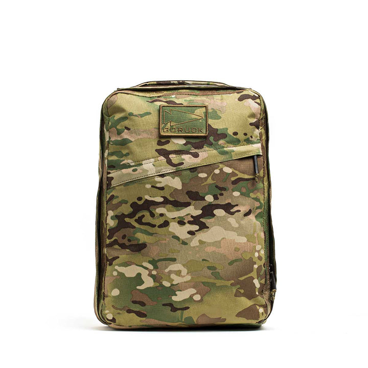 The GR0 - X-PAC is a lightweight rucksack with a camouflage pattern, top handle, front zipper, GORUCK logo patch, and made from durable waterproof material.