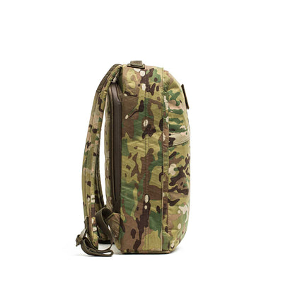 Side view of the GR0 - X-PAC, a lightweight, waterproof rucksack in a camouflage pattern with two shoulder straps, displayed on a white background.