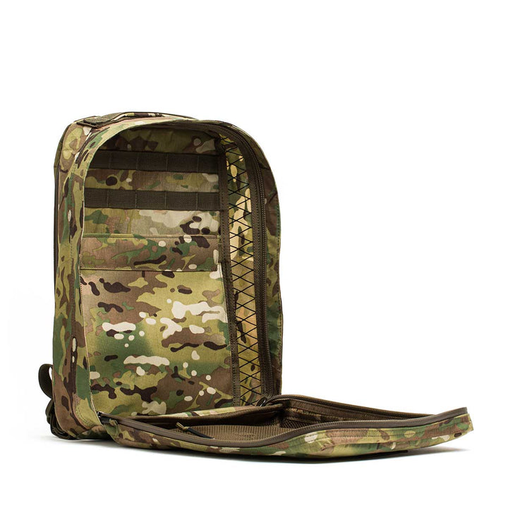 The GR0 - X-PAC is a lightweight, waterproof rucksack in a camouflage pattern, shown upright with its front compartment unzipped and open.