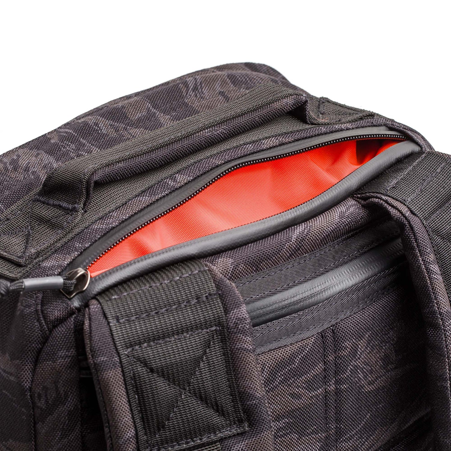 Close-up of the GR1 USA - Cordura, an everyday carry rucksack in black with an open zipper, revealing a bright orange lining—engineered for Special Forces-grade durability.