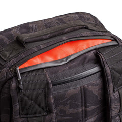 Close-up of a black camouflage GR1 USA - Cordura rucksack with an unzipped pocket revealing a bright orange lining, showcasing this Special Forces grade everyday carry backpack.