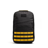 The GR1 rucksack backpack features yellow horizontal straps, a top handle, and is crafted from Special Forces grade materials, shown against a plain white background.