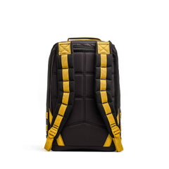 The GR1 rucksack, shown from the back, features a black design with padded yellow shoulder straps and a yellow top handle.