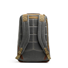 The GORUCK GR1 USA - Heritage rucksack, displayed from the back, features a gray and brown color scheme with padded shoulder straps and a quilted design. Its waxed canvas construction is complemented by a top handle and stitching details that enhance its sturdy appearance. The backdrop is plain white.