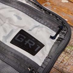 Close-up of the GR1 rucksack interior with a visible logo patch on wood, highlighting this American-made, Special Forces-grade backpack designed for everyday carry.