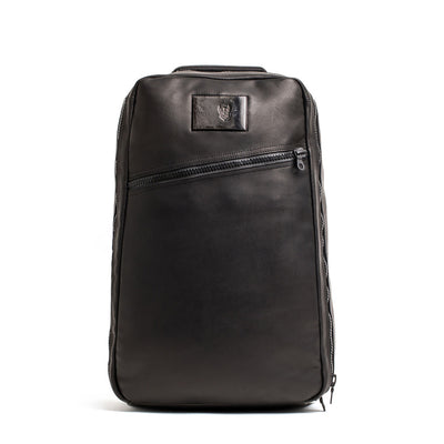 The GR1 USA x Carryology - Berserker Viking is a sleek black leather backpack featuring a diagonal front zipper and a small rectangular patch near the top, inspired by the bold spirit of Viking warriors.