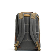 The GR1 USA - Heritage by GORUCK is displayed against a white background, featuring its gray waxed duck canvas with padded shoulder straps and brown accents. The visible stitching and adjustable straps enhance its functionality, while the top handle and rear quilted padding contribute to this heritage rucksack's classic charm.