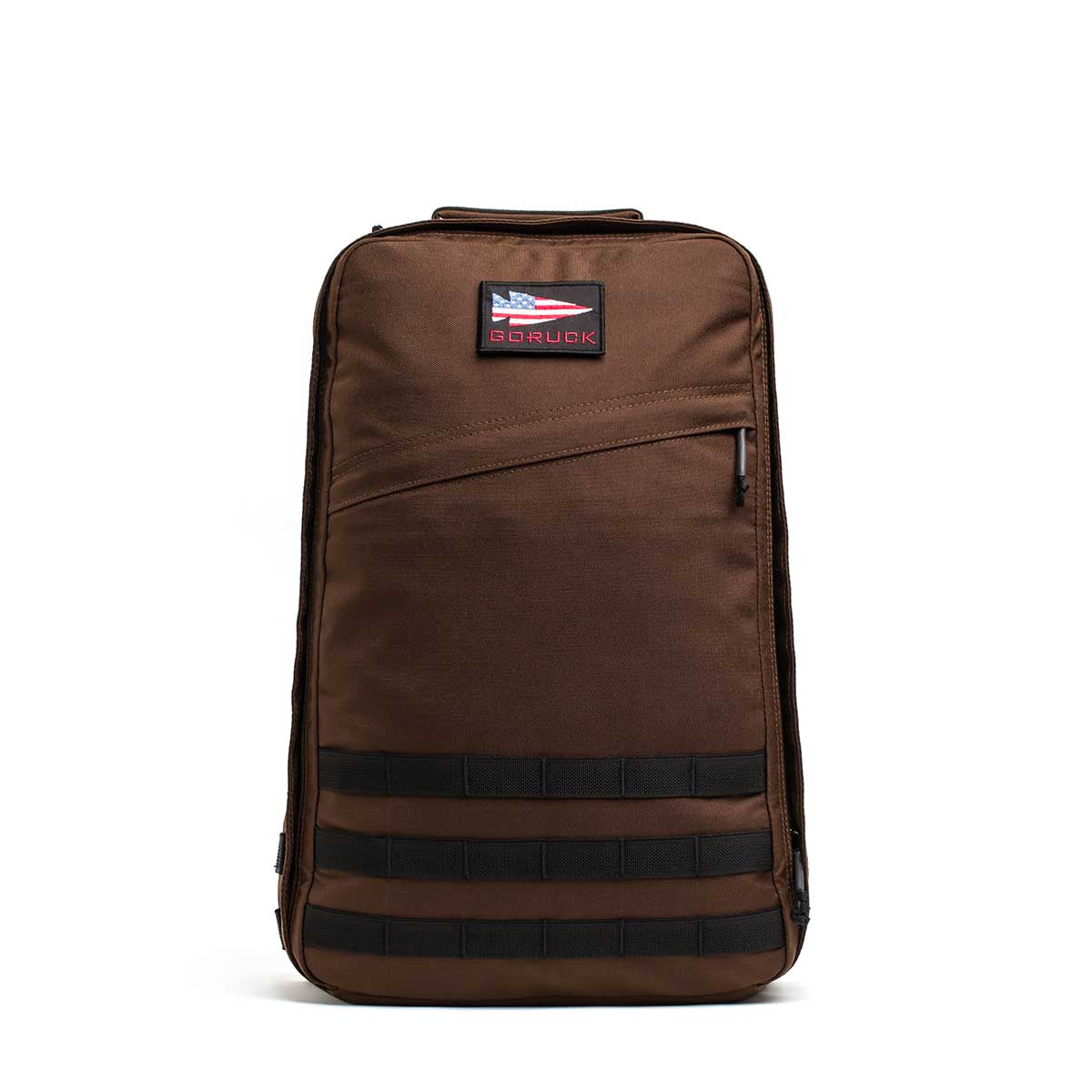 The GR1 is a brown rucksack featuring a front zipper pocket, horizontal webbing, and a rectangular patch near the top, built to Special Forces grade backpack standards.
