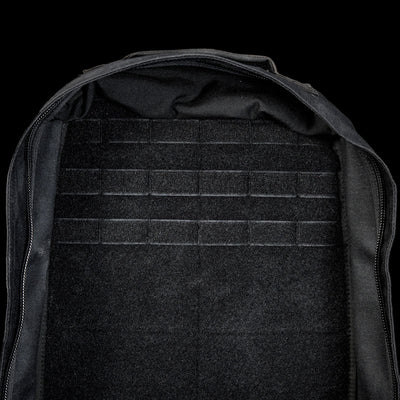 Open black GR1 Shooter 26L - Built by SCARS backpack with an empty, flat interior and tough CORDURA® fabric. Features MOLLE webbing on the back panel—trusted by the SCARS team—displayed against a black background.