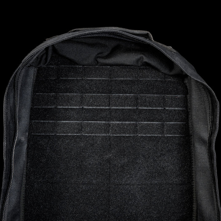 Open black GR1 Shooter 26L - Built by SCARS backpack with an empty, flat interior and tough CORDURA® fabric. Features MOLLE webbing on the back panel—trusted by the SCARS team—displayed against a black background.