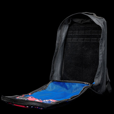 A black GR1 Shooter 26L - Built by SCARS backpack is open, showing a blue mesh pocket and spacious main compartment made from durable CORDURA® fabric, set against a black background.